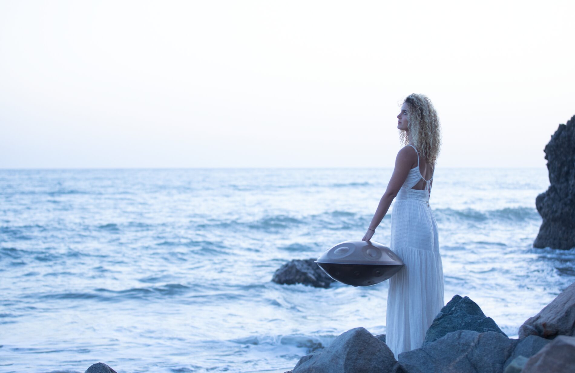Roni with handpan by the ocean