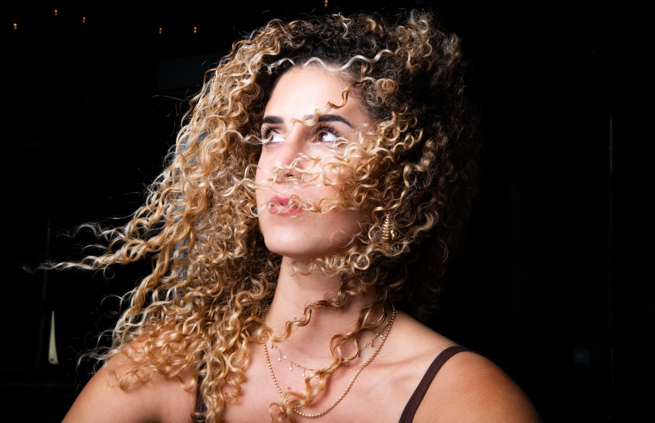 Roni with windswept hair in golden light